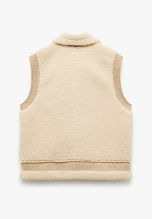 Chaleco de forro polar beige con cuello, paneles laterales acanalados y un dobladillo inferior liso. Textura suave, sin cierres, diseño sin mangas.