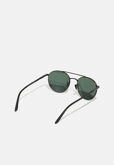 Round sunglasses with dark green lenses, black metal frame, and slim arms. Includes a nose bridge and showcased on a white background.