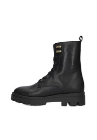 Zwarte leren enkelboot met vetersluiting, textuurafwerking, robuuste rubberen zool en twee gouden accentdetails aan de buitenzijde.