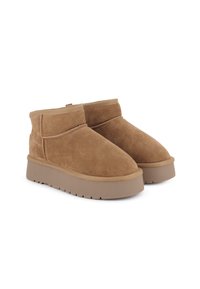 Botas de tobillo de ante marrón con punta redonda, detalles de costura y una suela de plataforma gruesa para mayor altura. Diseño minimalista.
