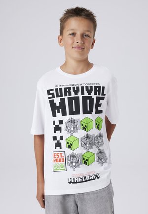 Witte katoenen T-shirt met Minecraft Creeper graphics in zwart en groen. Tekst luidt "SURVIVAL MODE" met pixelachtige designelementen.