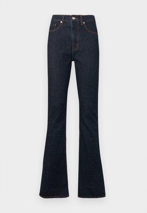 Ciemnoniebieskie dzwony z denimu z wysokim stanem, z pomarańczowym przeszyciem, przednią kieszenią i pojedynczym zapięciem na guzik w pasie.