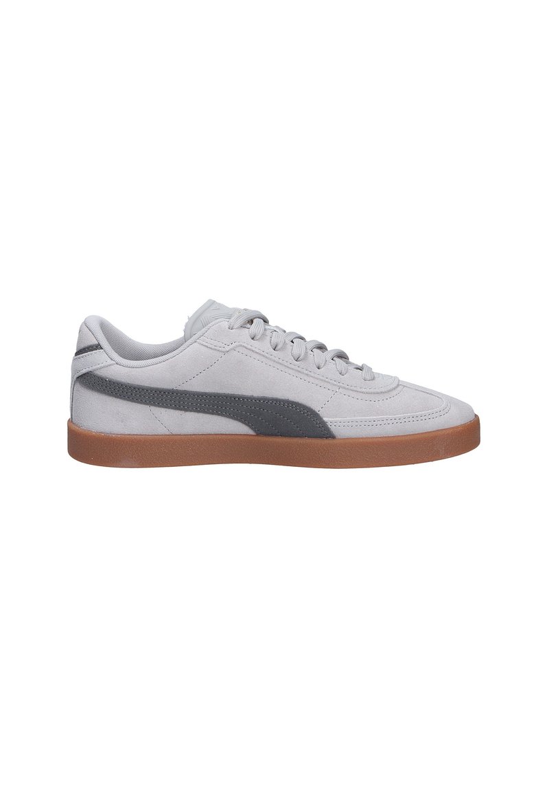 Sneaker en suède gris avec une semelle en caoutchouc marron, présentant une bande grise plus foncée sur le côté, un corps texturé et des lacets plats.