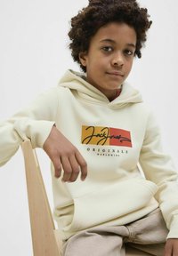 Kreminės spalvos džemperis su priekiniu grafiniu dizainu, kuriame užrašyta "Jack Jones Originals Worldwide" juodais ir raudonais akcentais. Minkšta medžiaga, su laisvu siluetu.