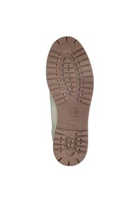 Semelle de chaussure en caoutchouc beige avec un motif de grip texturé et un logo. Le matériau supérieur gris clair est partiellement visible sur le côté avec une finition lisse.