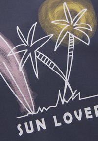 Marinblått tyg med vita konturgraphics av palmer, surfbrädor och en sol. Texten "SUN LOVER" i vitt längst ner.