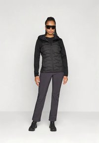 Mustast materjalist isoleeritud jakk esil lukuga, tekstuursete paneelidega ja istuva lõikega. Kandmiseks koos tumedate pükste ja mustade saapadega, moodustades funktsionaalse välimuse.