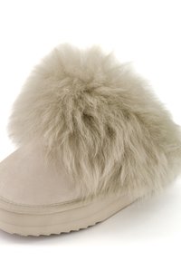 Botte d'hiver beige avec une fourrure épaisse, douce et moelleuse couvrant la cheville et le dessus du pied, dotée d'une semelle en caoutchouc plate pour une bonne adhérence.