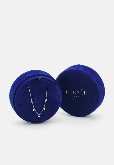 Στρογγυλό μπλε βελούδινο κουτί κοσμημάτων με χρυσό κείμενο. Περιέχει μια ασημένια αλυσίδα με πολλούς μικρούς στρογγυλούς μενταγιόν.