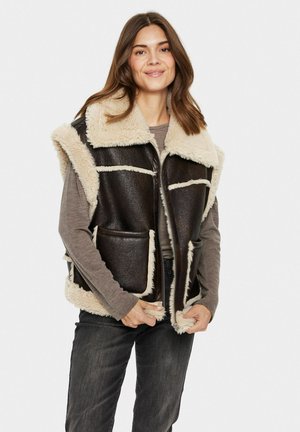 Bruine faux-lederen vest met beige schapenvachtvoering, grote kraag en zakken aan de voorkant; mouwloos ontwerp met contrasterende stikseldetails.