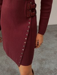 Bordowa dzianinowa spódnica z podwójnymi klamrami i srebrnymi zatrzaskami po boku; teksturowany materiał o dopasowanym kroju.