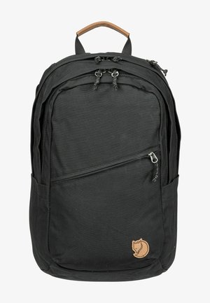 Zaino nero realizzato in tessuto resistente, con una maniglia in pelle marrone, numerosi scomparti con zip e una piccola patch con il logo.