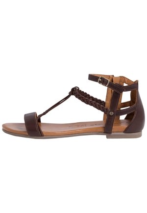 Sandale en cuir marron avec une sangle tressée pour les orteils, une boucle à la cheville et un design découpé. Semelle plate avec une semelle intérieure beige, texturée pour une meilleure adhérence.