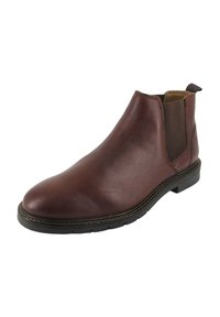 Stivale Chelsea in pelle marrone con pannelli elastici laterali, tacco basso, texture liscia e cuciture a contrasto lungo la suola.
