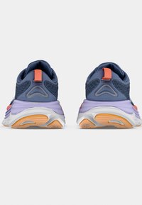 Blå sportskor med en strukturerad ovandel, med orange detaljer och en lila mellansula. Vit yttersula med ljusorange inslag.
