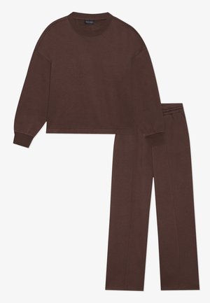 Braunes Baumwoll-Loungewear-Set mit einem kurz geschnittenen Pullover mit langen Ärmeln und passenden geraden Hosen, beide mit elastischen Abschlüssen.