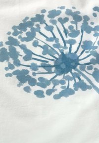 Illustration de tête de graine de pissenlit bleue avec des tiges rayonnantes et des grappes arrondies sur un fond de tissu blanc.