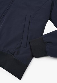 Giacca bomber blu navy con polsini e orlo elasticizzati, dotata di una tasca laterale e tessuto liscia e testurizzata per il comfort.