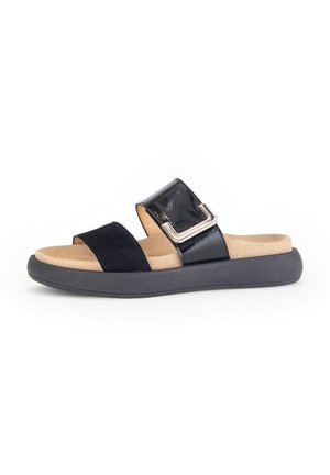 Black slide sandals featuring a glossy leather upper, suede strap, and a cushioned tan footbed, with a sturdy black rubber sole.