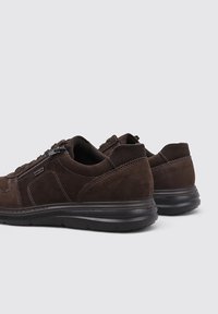 Chaussures en daim marron au design élégant, dotées d'une tige texturée, d'une semelle en caoutchouc noire et d'un détail de fermeture éclair latérale.