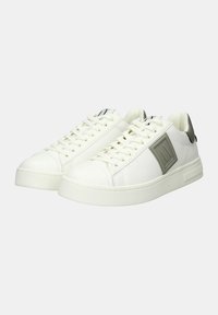 Sneaker bianche con una finitura liscia, caratterizzate da un pannello di accentuazione grigio, punta tonda, lacci piatti e una suola in gomma testurizzata.