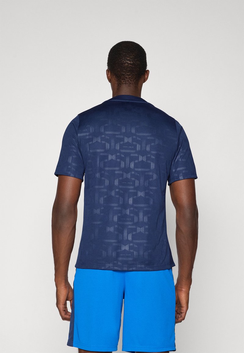 Camisa de manga corta en color navy con un patrón geométrico texturizado en la parte posterior, con un acabado suave y un escote redondo.