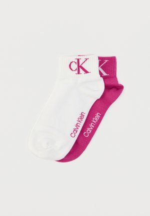 Șosete din bumbac cu manșetă rotundă, în alb și fucsia, cu manșete striate contrastante și logo imprimat „CK” și „Calvin Klein” pe fiecare.