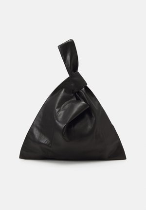 Mustaa nahkalaukkua, jossa on ainutlaatuinen solkilukko, kolmion muoto, sileä pinta ja minimalistinen muotoilu. Ei näkyvää kiinnitystä tai kuvioita.