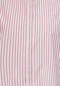 Valge särk, millel on vertikaalsed punased triibud ja viis nähtavat valget nööpi keskel ees kinnitatud.