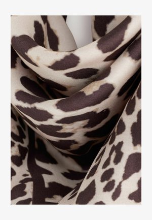 Glat stof med beige og mørkebrune uregelmæssige leopardpletter og folder, der fremhæver tekstur og mønsterdetaljer.