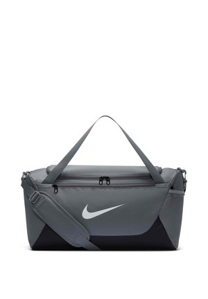 Sac de sport Nike gris et noir avec bandoulière, poignées, poche avant zippée et poche latérale en mesh.
