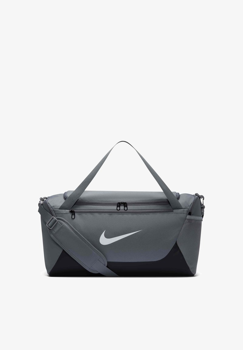 Γκρι και μαύρη τσάντα Nike με ιμάντα ώμου, χερούλια, μπροστινή τσέπη με φερμουάρ και δίχτυ στην πλευρά.