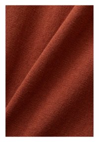 Tissu texturé d'une couleur chaude rouille, avec une apparence douce et lisse, présentant un motif de tissage subtil et un léger éclat provenant des fibres.