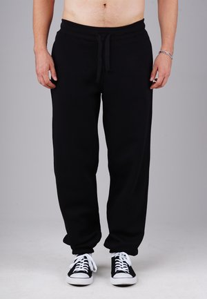 HUSTLE - Tracksuit bottoms - black