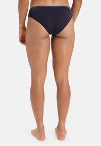 Mörkblå bomullsbikiniunderdel med låg midja. Slät yta och minimal sömnadsdetalj, designad för komfort och täckning.