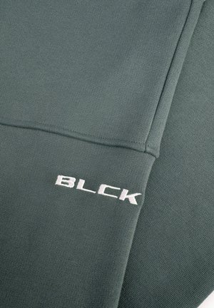 Groene sweatshirt met een textuurstof, een gladde afwerking en een geborduurd "BLCK" logo in het wit aan de onderzijde.