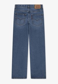 Pantalones vaqueros de denim azul con corte recto, que presentan dos bolsillos traseros con detalles de costura y una etiqueta de cuero en la cintura.