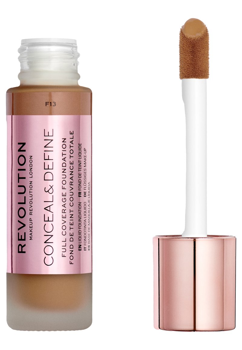 Fond de teint couvrant intégral dans une bouteille en verre transparent, teinte marron clair avec une étiquette rose. Comprend un applicateur blanc avec un embout doux.