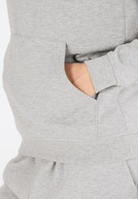 Jasnoszara bluza z ribb strony mankietami i dolnym wykończeniem. Posiada boczną kieszeń oraz miękką, teksturowaną tkaninę. Prosty, codzienny design.