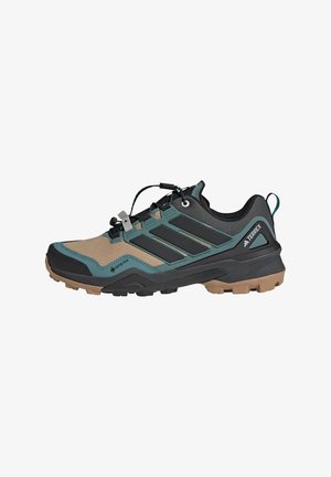 Trail running shoe featuring a black and tan mesh upper, teal accents, and a rugged rubber sole with deep treads for traction.