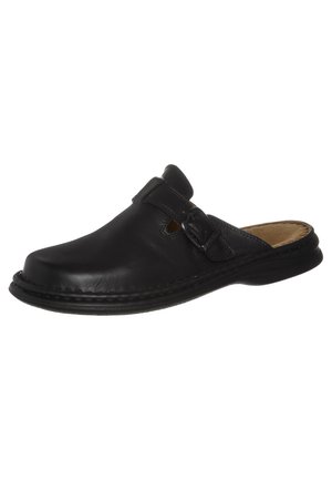 Chaussure slip-on en cuir noir avec bout rond, sangle ajustable, panneau latéral texturé et semelle en caoutchouc plate.