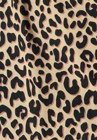 Le tissu à imprimé léopard présente de grands taches noires sur un fond beige avec des sous-tons roses subtils, une texture lisse et un design fluide.