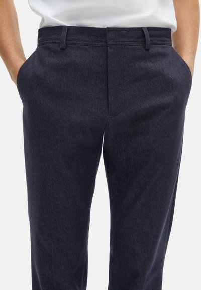 Donkerblauwe, slim-fit broeken met een gladde textuur, riemlussen en zijzakken. Strak ontwerp met een op maat gemaakte snit en minimale details.