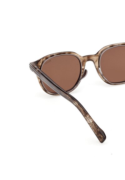 Occhiali da sole marroni con motivo, dalla forma a occhi di gatto, caratterizzati da montature in acetato marrone trasparente e aste marrone scuro dalla texture lavorata.