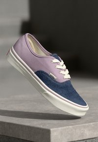 Vans sneakers featuring a purple upper with a navy blue textured suede side, white laces, and a white rubber sole with red accents.