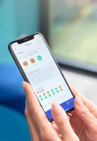 Smartphone con cornice nera che mostra un'interfaccia di app per la salute, con icone arancioni e verdi, testo e grafici su uno sfondo chiaro.