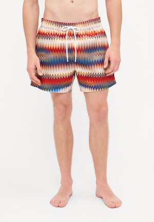 Heren zwemshorts met een zigzagpatroon in rood, blauw en crème. Voorzien van een elastische tailleband met een witte koord.