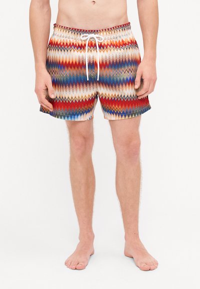 Heren zwemshorts met een zigzagpatroon in rood, blauw en crème. Voorzien van een elastische tailleband met een witte koord.