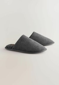 Graue hausschuhe zum Hineinschlüpfen mit einem strukturierten Stoffobermaterial und einem weichen, mit Fleece gefütterten Innenraum. Abgerundete Zehenpartie und flache Gummisohle.