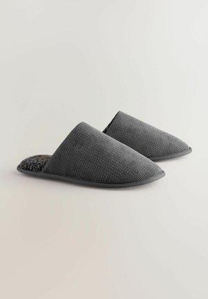 Chaussons gris à enfiler avec un dessus en tissu texturé et un intérieur en polaire douce. Bout arrondi et semelle plate en caoutchouc.